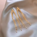 Elegant gold multi-layered tassel earrings with baguette zircons on silk background - Gold
