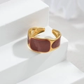 Nahaufnahme eines vergoldeten Rings mit burgunderrotem Emaille auf weißen Blöcken - R742-B-hong / Gold Rot