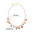 Detail view of woven cord necklace with gold charms including sun and clover symbols - Orange White Cord (OLBN2229-E)