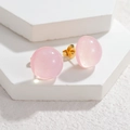 Boucles d'oreilles boules en résine rose avec paillettes et tiges dorées sur fond blanc - Rose