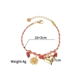Détail d'un bracelet tressé avec breloque soleil, cœur doré et pierres rouges - Style Soleil et Coeur (OLBB1215-C)