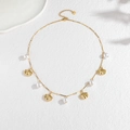 Collana dorata in acciaio inox con conchiglie e perle bianche su sfondo minimalista - Oro/Perla Bianca (N2280)