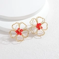 Elegante hohl gewebte Blumenohrringe aus 18 Karat Gold mit roten Perlen auf weißem Sockel - Rot