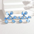 Blue and 18k gold floral earrings arranged on minimalist white geometric display - Blue