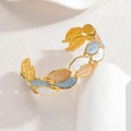 18k Gold Armreif mit Blattmotiv und Emaille in Blau Weiß und Rosa auf weißem Hintergrund - Off-White