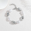 Bracciale di perle barocche con elementi irregolari in acciaio inossidabile argento su sfondo bianco - Color Acciaio