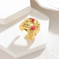 Anello a fascia larga martellata in oro con pietre rosse su uno sfondo di pietra sobrio - Rosso