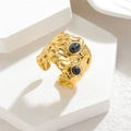 Anello largo martellato dorato con due pietre nere su supporto geometrico bianco - Nero