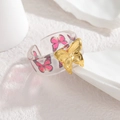Verstellbarer Ring aus Harz mit Schmetterlingsmuster und goldener Schmetterlingsverzierung - Rosarot