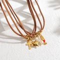 Collier bohème multicouche en cordon brun avec pendentifs croix et cœur dorés sur blanc - Style Croix & Main (S-N2307-F)