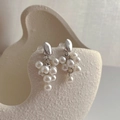 Elegant silver grape cluster earrings with white pearls hanging on ceramic display - Silver