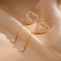 Detalle de pendientes de corazón dorados con borlas sobre fondo de raso champán - Bañado en Oro 18K (Etiqueta 24K) / Dorado