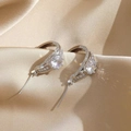 Elegantes pendientes de plata con circonitas cúbicas sobre fondo de seda dorada - Plateado