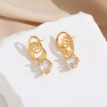 Modische 18K vergoldete Creolen mit funkelnden Zirkonia-Tropfen auf Marmorhintergrund - 18K Gold Beschichtet / Gold