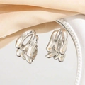 Three-layer silver metallic hoop earrings on a decorative white tray with soft fabric - 24K / Silver