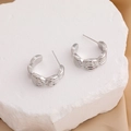 Silver C-shaped hoop earrings with triple horizontal groove texture on stone surface - 18K Gold / Silver