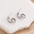 Orecchini a cerchio a C argentati con perla metallica a righe su sfondo di pietra e stoffa - 18K / Argento