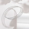 Macro detail van zilveren gedraaide armbanden met een gevlochten textuur - Zilveren Gedraaide Spiraal Textuur (CXB1250-01)