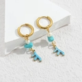 Boho-Ohrringe Gold mit weißer Perle und blauem Korallenanhänger auf Steinpodest - Blaue Koralle Stil