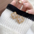 Elegante goldene Kleeblatt-Ohrringe mit Zirkonia auf einem Strickhintergrund präsentiert - 18K Gold / Gold (A0822AJ)