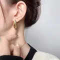 Eleganti orecchini a goccia dorati dal design geometrico lucido indossati da modella - Placcato Oro 18K / Oro