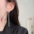 Silver rhinestone stud earrings with long chain tassels worn by model in business attire - 18K Platinum Plated / Silver