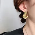 Unregelmäßige vergoldete Ohrhänger mit Hammerschlag-Textur an einem weiblichen Model - 24K / Gold (A0721A)
