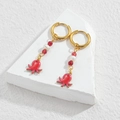 Detail of gold hoop earrings with red octopus charms and elegant pearl beads - Red Octopus Style