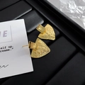 Dettaglio macro di orecchini geometrici dorati con trama martellata su pelle nera - 24K / Oro (A0805B)