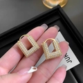 Gros plan détaillé des boucles d'oreilles en U dorées 24K avec cristaux pavés étincelants - 24K / Or (A0635A)