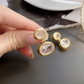 Close-up of gold oval drop earrings with two cubic zirconia and hollow metal textures - 24K / Gold (A0610A)