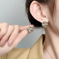 Detalle de pendientes esféricos huecos bañados en oro de 18K puestos en la oreja del modelo - Pequeño (A0629C) / Plateado