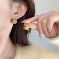 Close-up of golden C-shaped hoop earrings with textured granular surface on a model - 18K Gold Plated Style (A0627B)