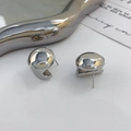 Detailaufnahme polierter silberner geometrischer Ohrstecker auf einem Metalltablett - Silber (A0730A)