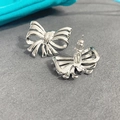 Macro shot of silver bow stud earrings with polished finish and secure push-back closures - Silver (A0137C)