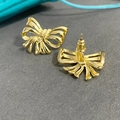 Detailed view of hollow gold-tone bow stud earrings with intricate ribbon texture - Gold (A0137C)