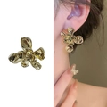 Elegante orecchino a lobo a fiore dorato mostrato singolarmente e indossato da modella - Oro 18K / Oro