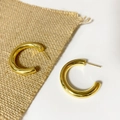 Detailed view of polished gold chunky C-shaped hoop earrings on natural jute texture - Large Style / Gold