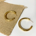 Detailed view of polished gold-finished brass hollow C-hoop earrings on a linen texture - Extra Large Size / Gold
