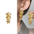 Elegante dreifache Blumen-Ohrhänger mit 18K Vergoldung, am Model präsentiert - Gold