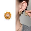 Orecchini a perno a girasole dorati con zircone ovale indossati da una modella - Oro