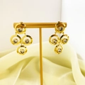 Detail view of geometric golden drop earrings with layered circles and zircon insets - Gold