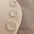 Detailweergave van drie maten zilveren kralen oorringen op een luxe sieradenstandaard - 1.3cm (Buitendiameter) / Zilver (Glanzend Verzilverd)