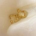 Detail von quadratischen vergoldeten Creolen mit Zirkonia-Steinen auf Seidenhintergrund - Gold (A0332C)