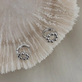 Macro view of silver geometric hoop earrings featuring dangling polished bead circle details - Silver (A0438A)