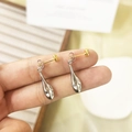 Detalle de pendientes bicolor oro y plata en forma de gota sostenidos por los dedos - Gota de plata con pin de oro (A0335B)