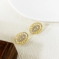 Macro view of gold plated oval stud earrings featuring sunburst metal edges and micro zircon - Gold