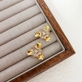 Detalle de pendientes chapados en oro de 18 quilates con circonitas y diseño floral único - Cobre Chapado en Oro Real de 18K + Circonita / Dorado