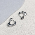 Dettaglio di orecchini a cuore placcati oro 18K con design moderno in metallo liquido - Argento