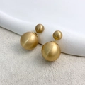 Detalle macro de pendientes de doble bola en metal dorado cepillado con textura mate - Oro Cepillado (A0601C)